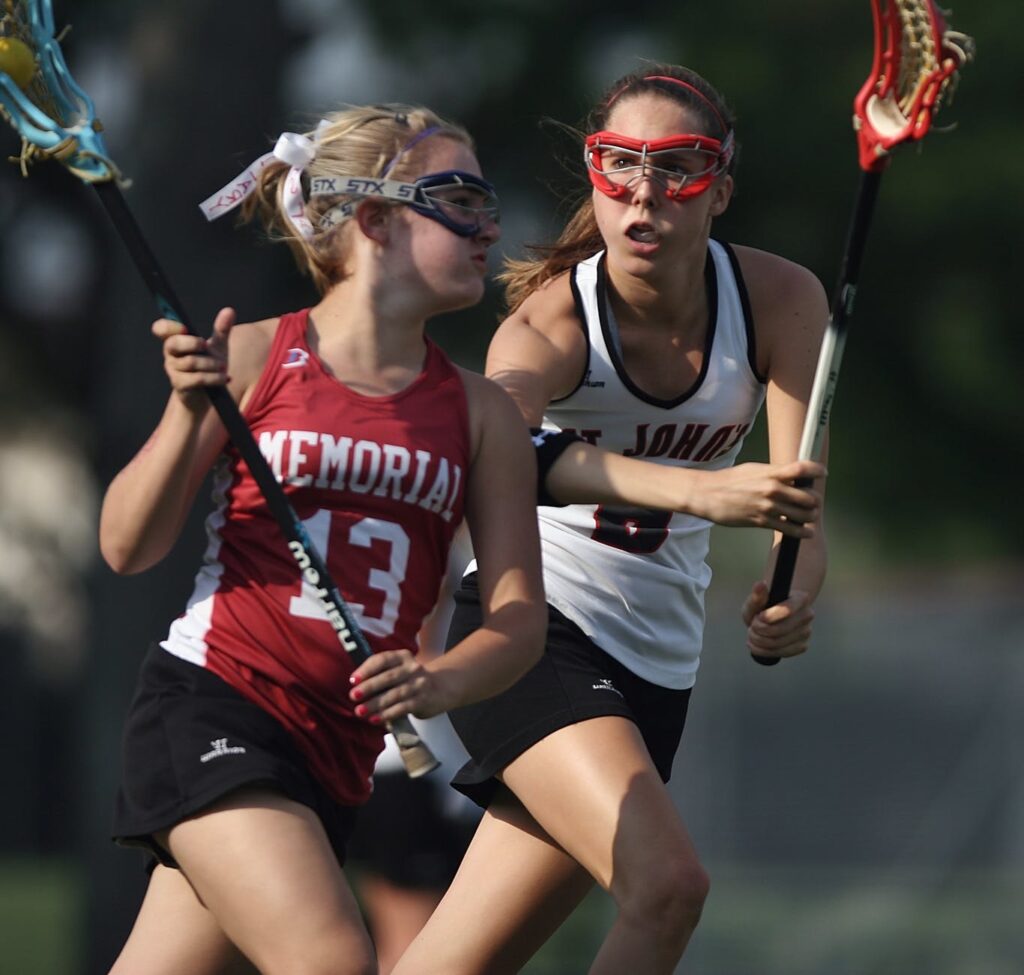 woman and girl playing lacrosse